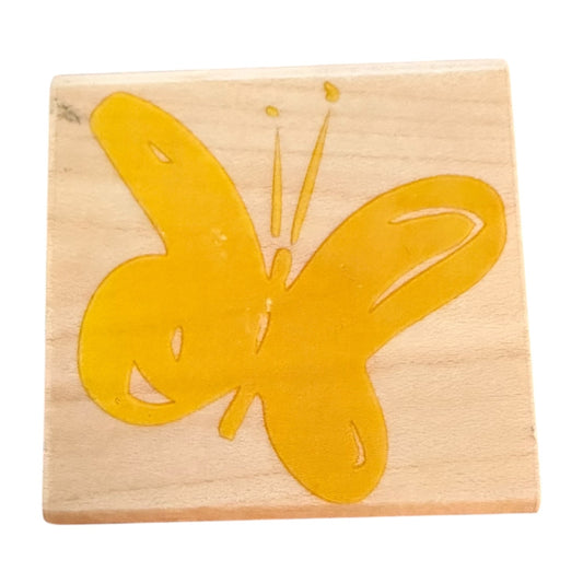 Wooden stamp with a yellow butterfly design on a white background