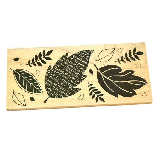 Wooden block with leaf designs and engraved text on a white background