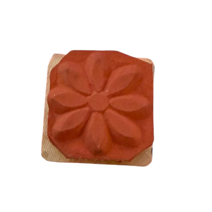 Flower rubber stamp on a wood block with a white background. 