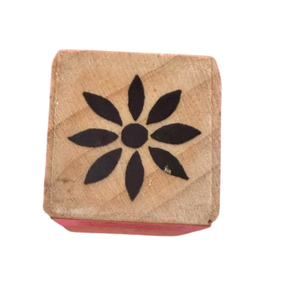 Black flower print on a wood block stamp on a white background. 