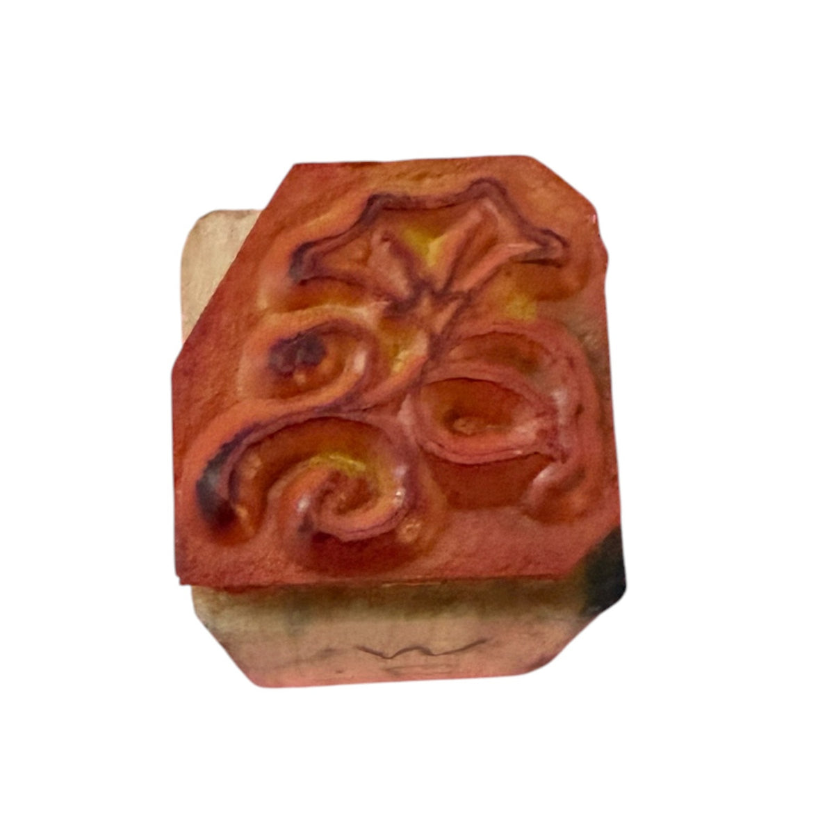 A wooden block with a rubber stamp of a floral design, shown on a plain white background.