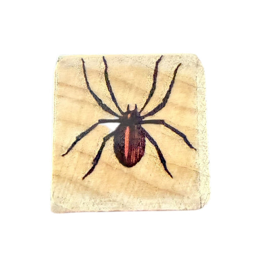 Stamp with a spider design on a wooden background