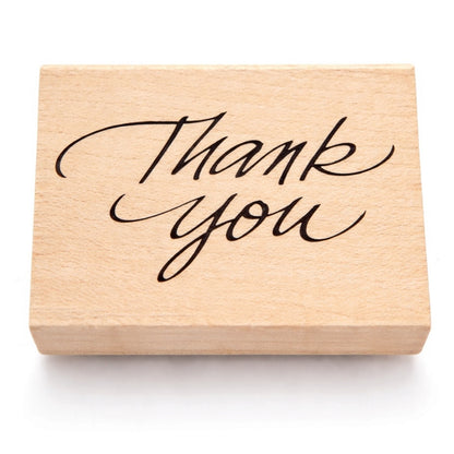 Wooden stamp with 'Thank you' text on a white background