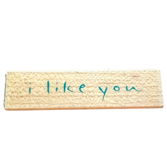 Wooden block stamp with 'i like you' text on a white background