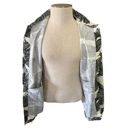 Mannequin wearing a [alm leaf patterned jacket while showing the jacket open on a white background