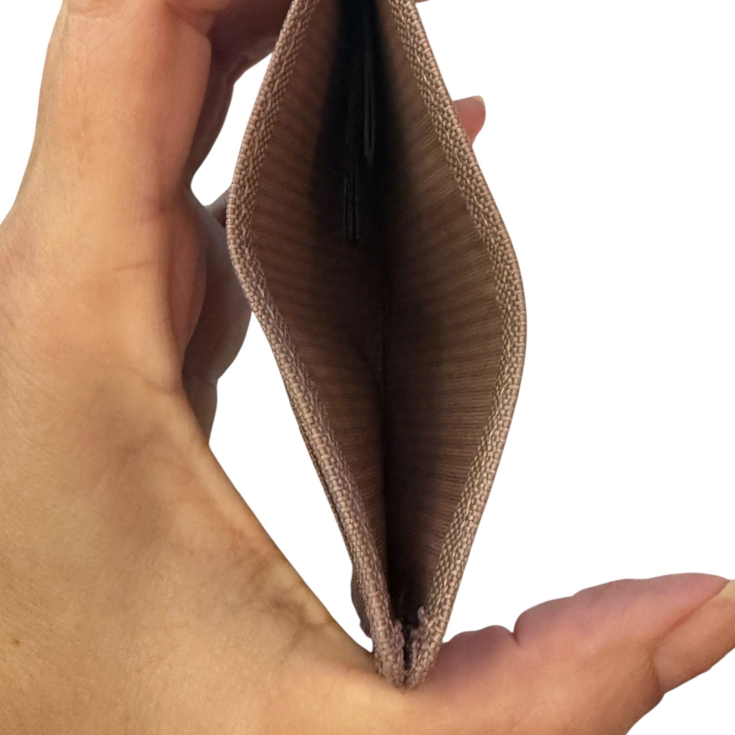 Hand holding an open beige wallet against a white background