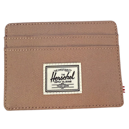 Beige wallet with Herschel Supply Co. label on a white background