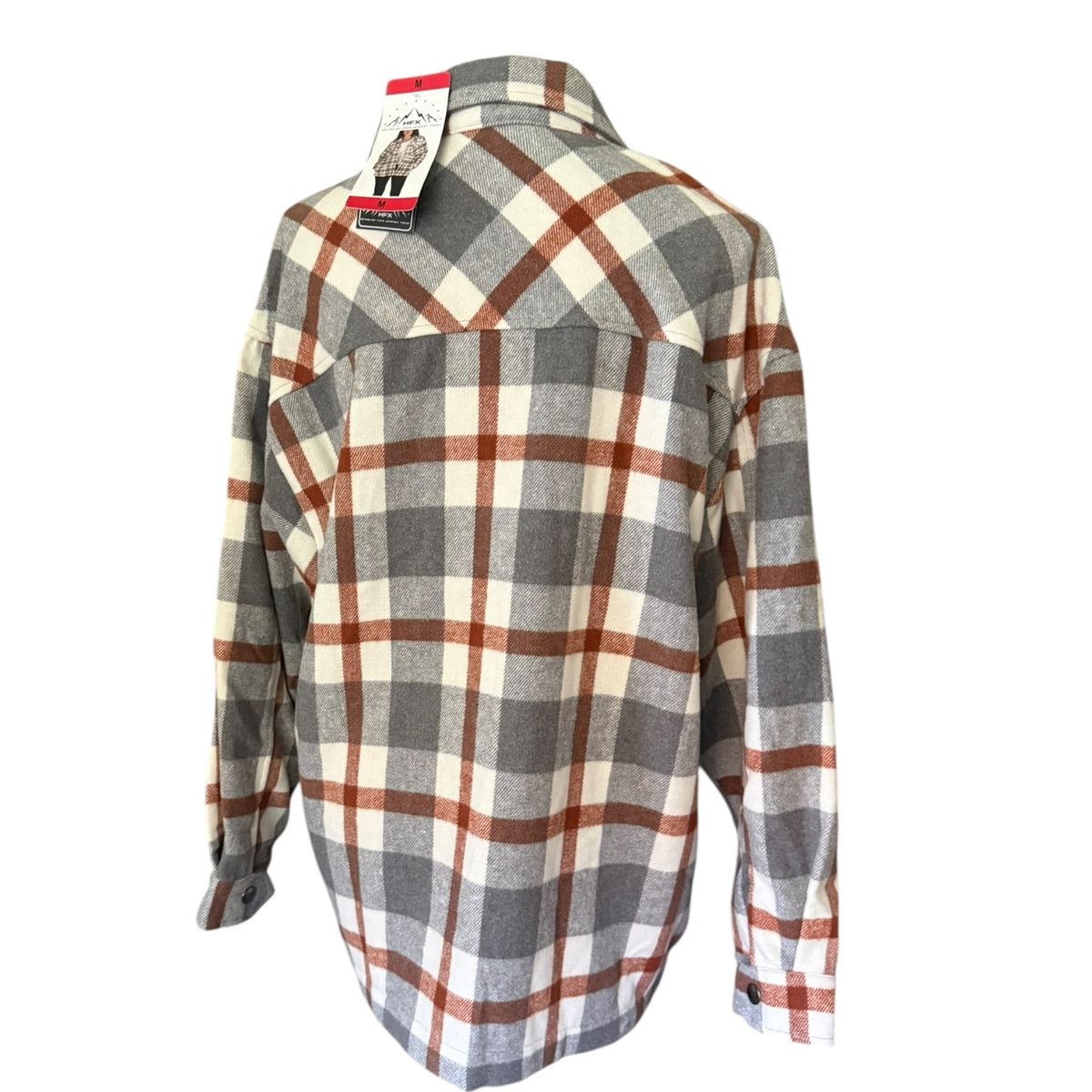A long-sleeve plaid flannel shacket, shown from the back with its retail tag still attached. The shirt features a classic plaid pattern in gray, off-white, and rust brown.