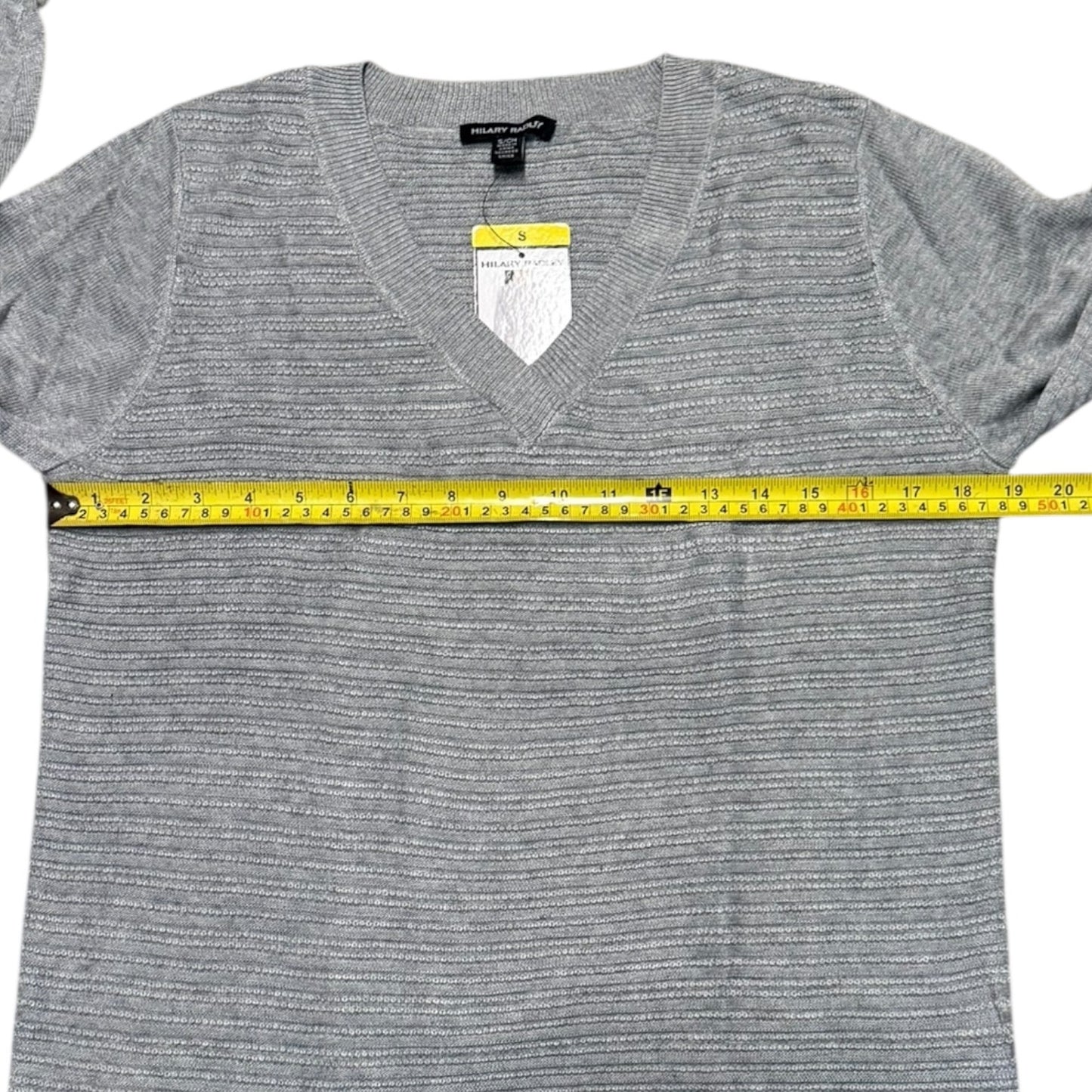 Gray sweater with a measuring tape around it on a white background