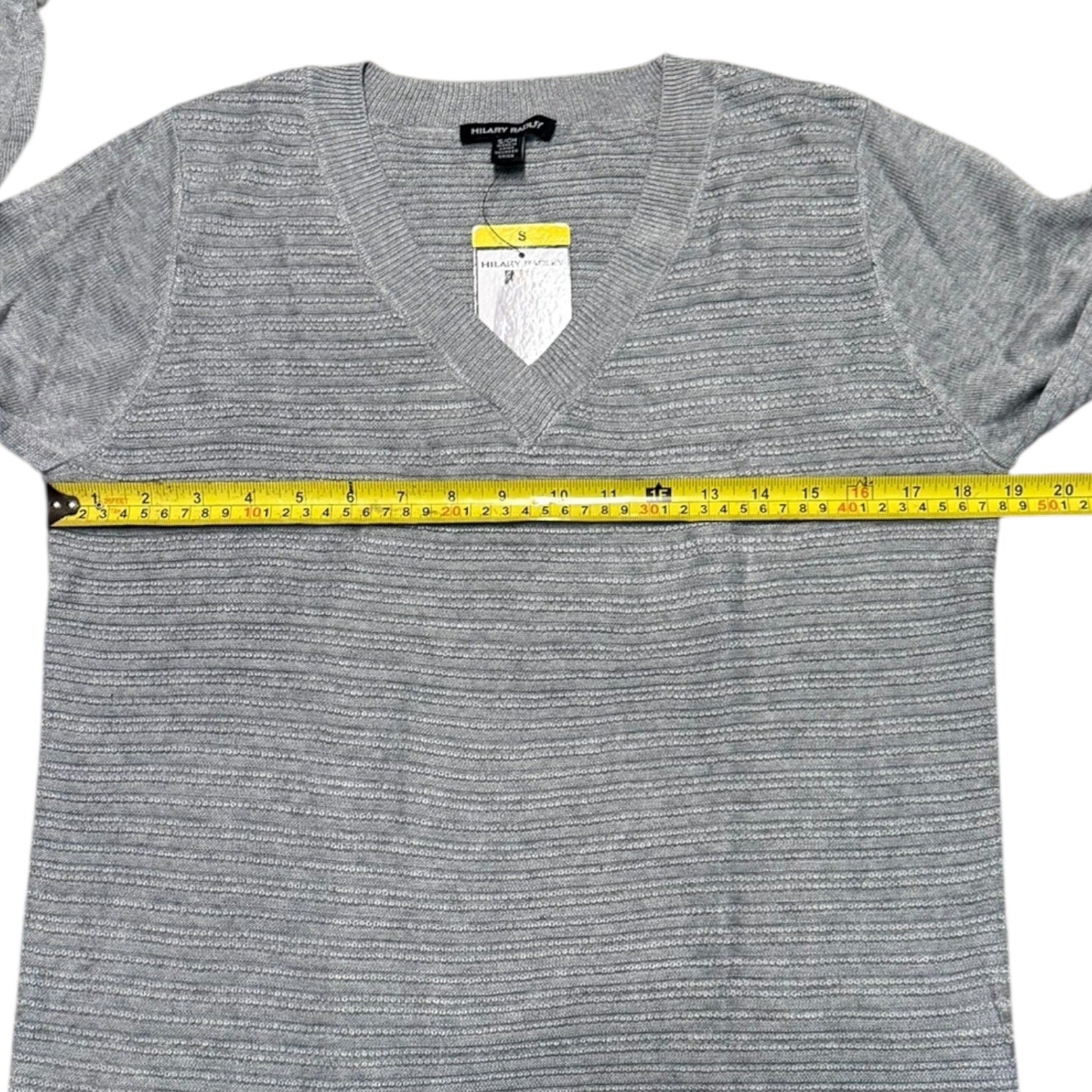 Gray sweater with a measuring tape around it on a white background