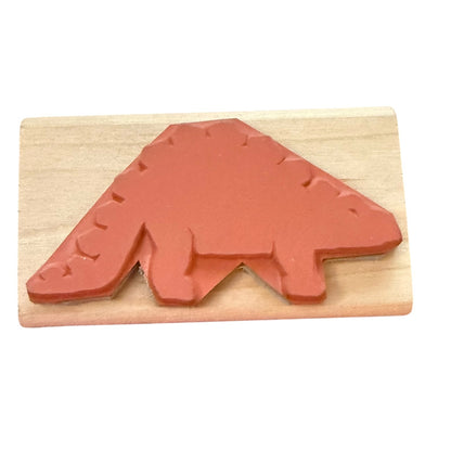A dinosaur-shaped rubber stamp in a terracotta red color, mounted on a light-colored wooden block against a plain white background.