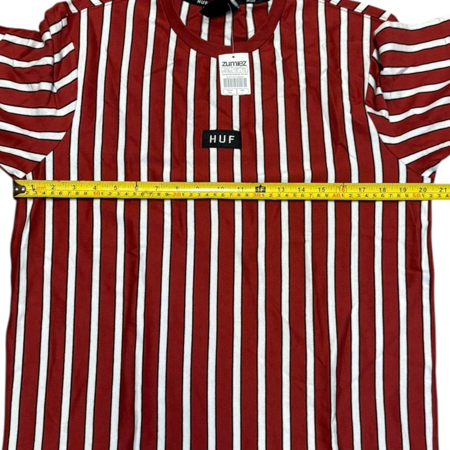 Red and white striped shirt with a measuring tape and brand labels on a white background