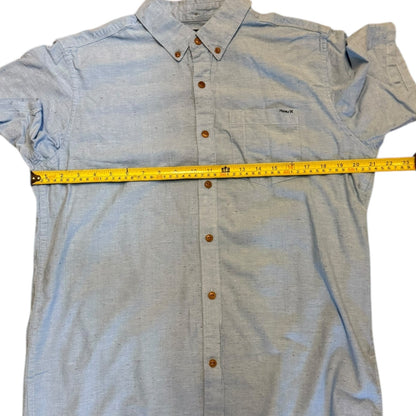 Light blue button-up shirt with a measuring tape on a white background