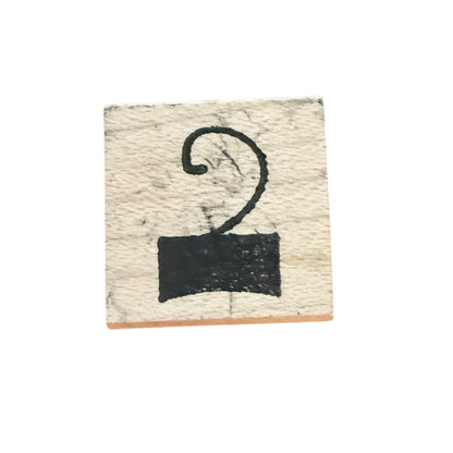 A square wooden stamp block featuring a hook or number 2 on a white back ground