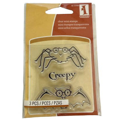 Packaging of clear mini stamps with spider, bat, and creepy designs on a beige background.