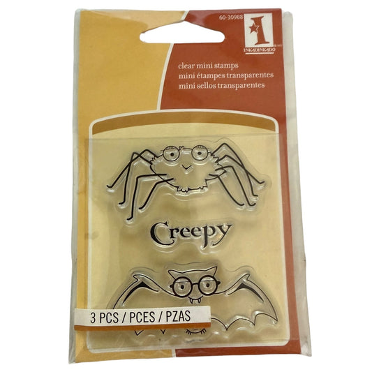 Packaging of clear mini stamps with spider, bat, and creepy designs on a beige background.