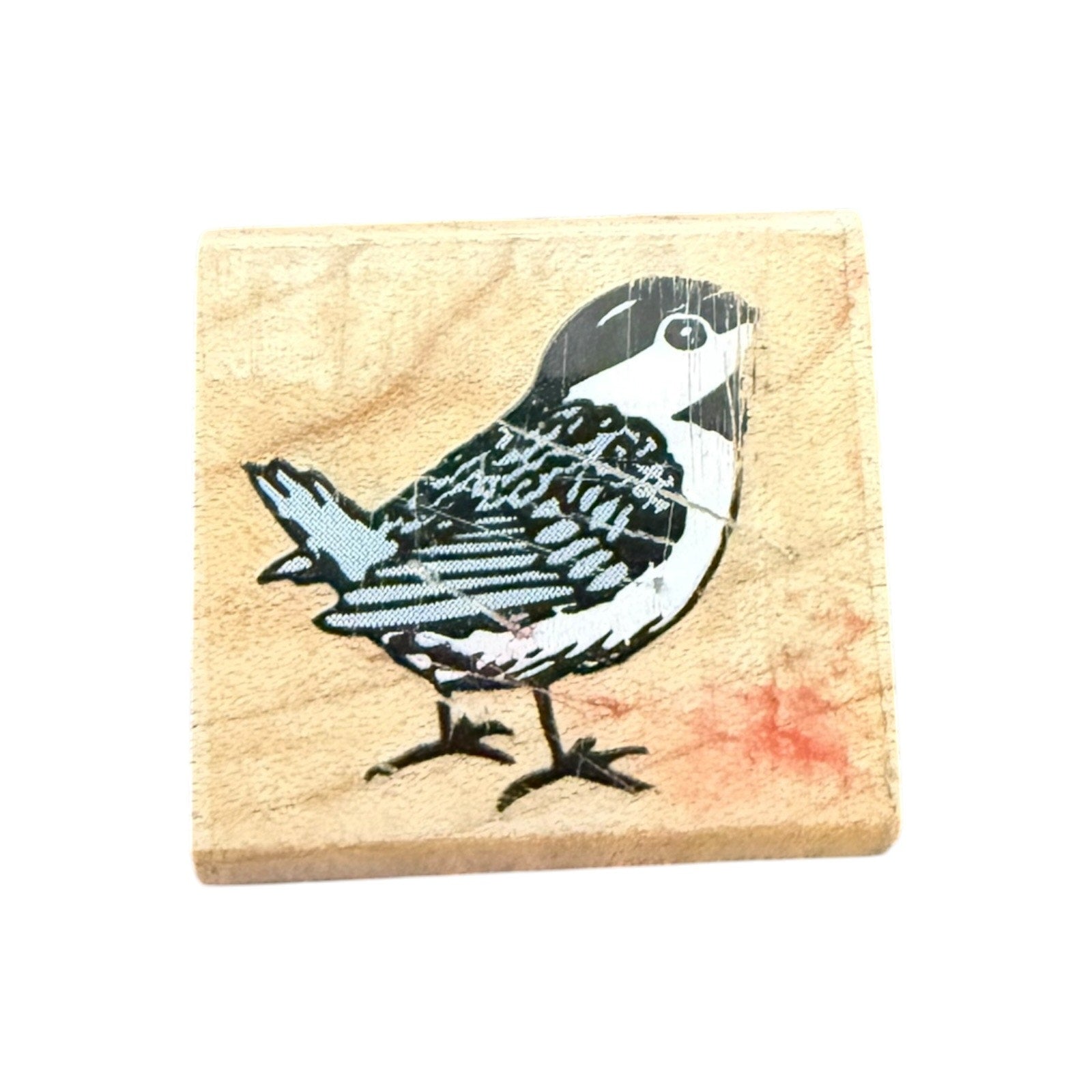 Wooden stamp with a bird design on a beige background