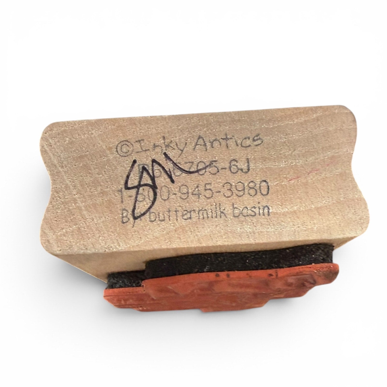 Wooden stamp with red ink pad on a white background