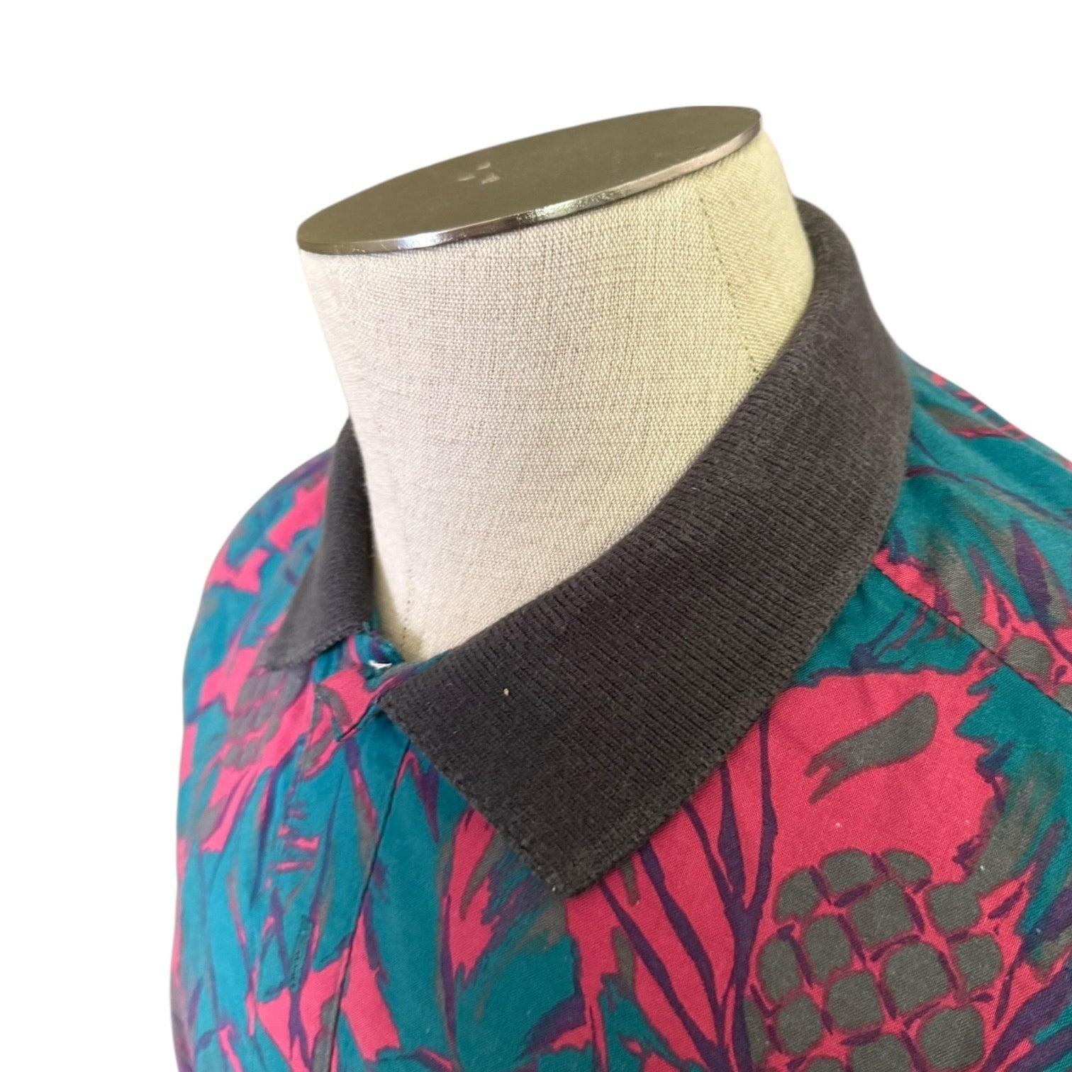 Mannequin wearing a colorful floral-patterned garment with a gray collar.