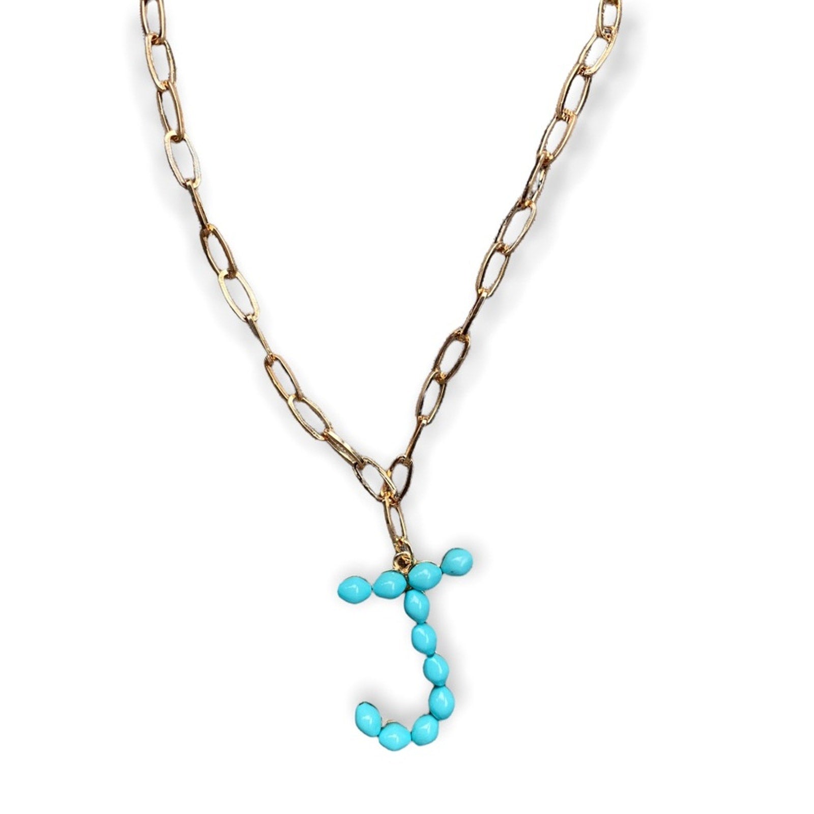 A gold-toned chain necklace featuring a pendant composed of small turquoise-colored beads arranged in the shape of the letter 'J', shown against a plain white background.