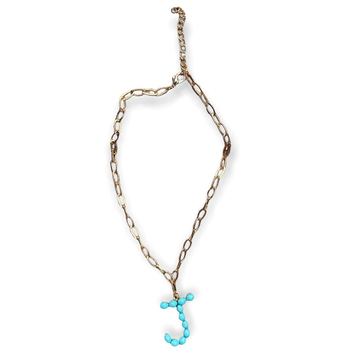 A gold-toned chain necklace with a dangling letter 'J' charm made of small turquoise beads, shown on a plain white background.