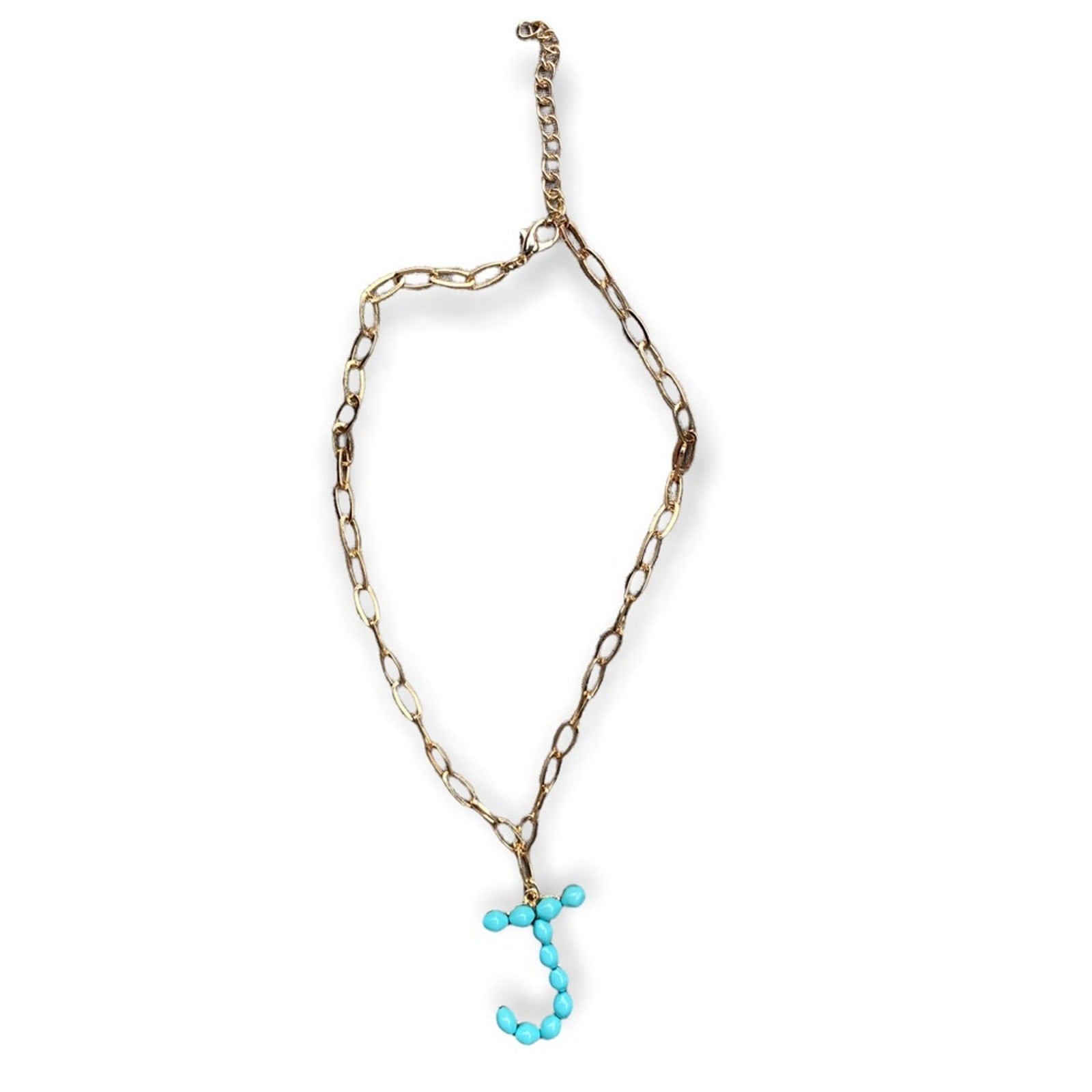 A gold-toned chain necklace with a dangling letter 'J' charm made of small turquoise beads, shown on a plain white background.