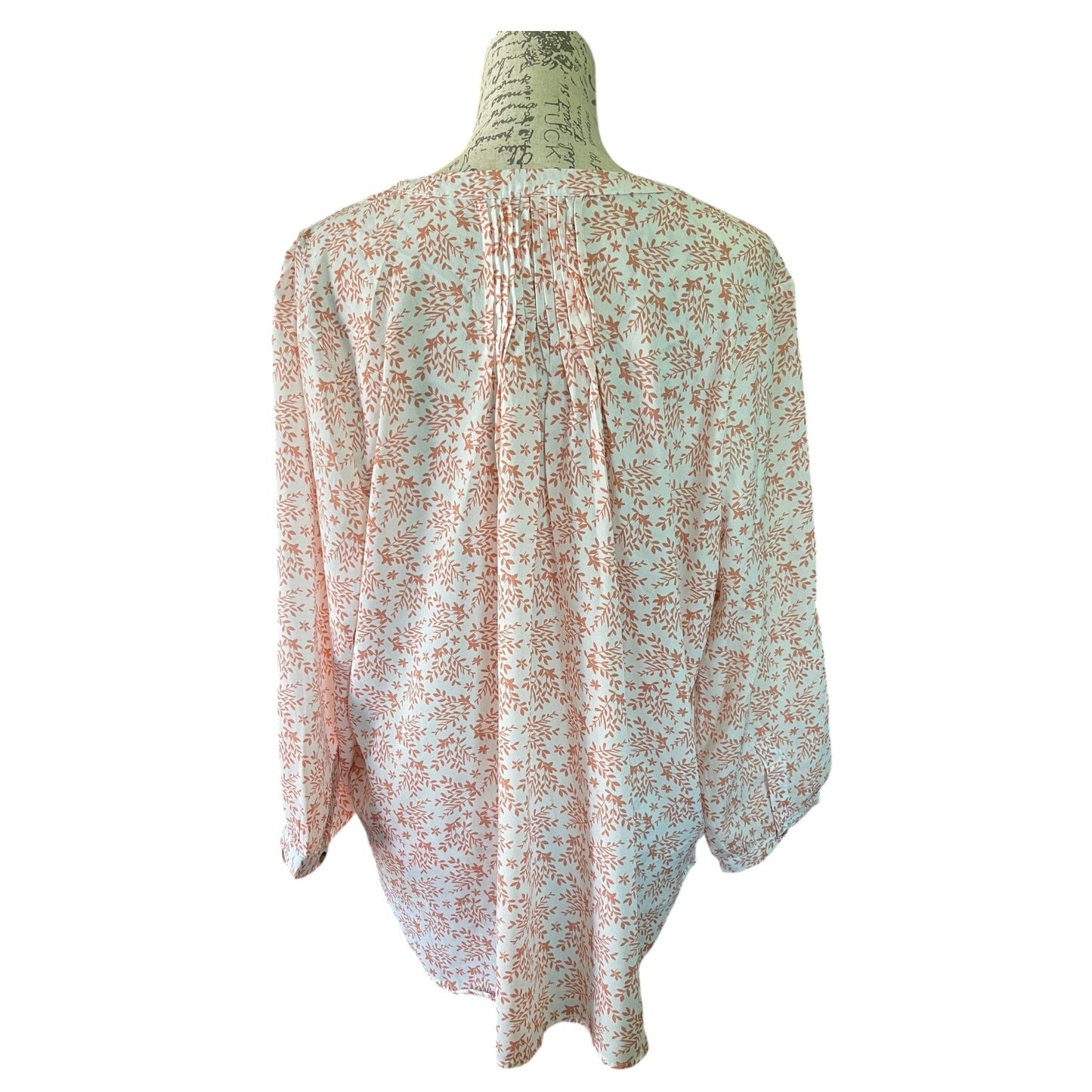 A l3/4 sleeve blouse with a floral print, displayed on a vintage dress form mannequin against a plain white background.