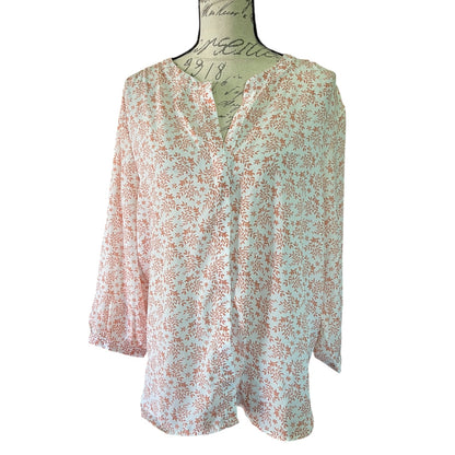 A lightweight, long-sleeve button-up blouse with a floral pattern in pink on a white background, displayed on a mannequin torso against a white background.