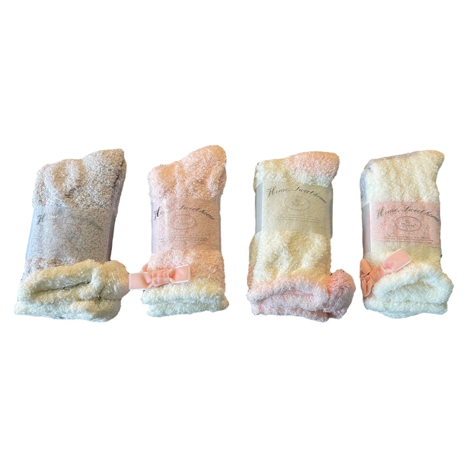 Four pairs of fuzzy socks with bows on a white background