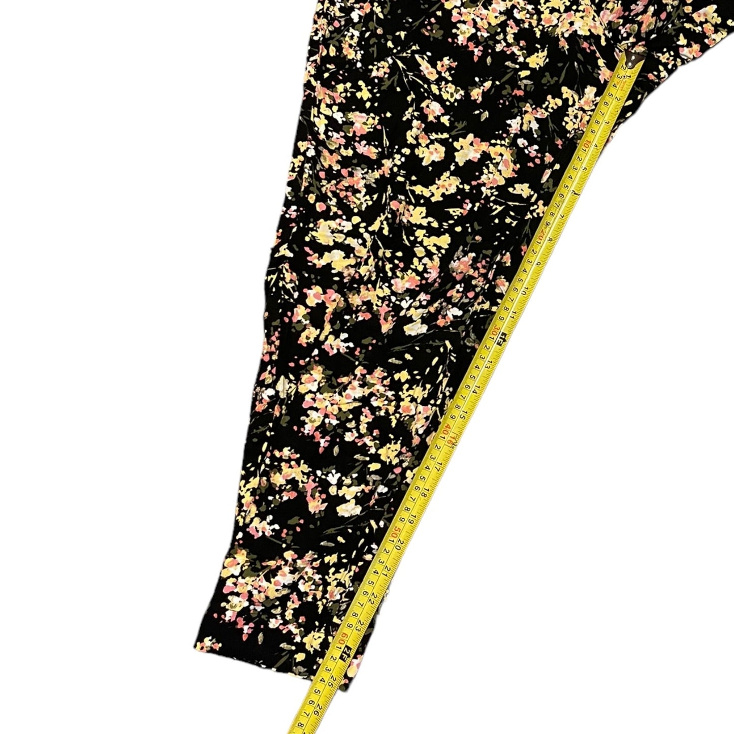 Floral-patterned fabric on a black background with a measuring tape for scale.