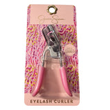 Pink eyelash curler with silver accents on a patterned pink packaging