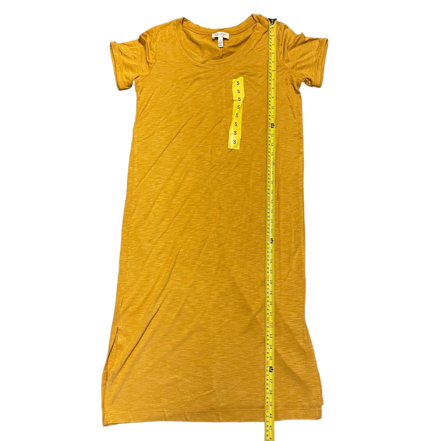 A mustard yellow short-sleeve t-shirt dress laid flat on a white background, with a yellow measuring tape running vertically down the front to show the garment's length.