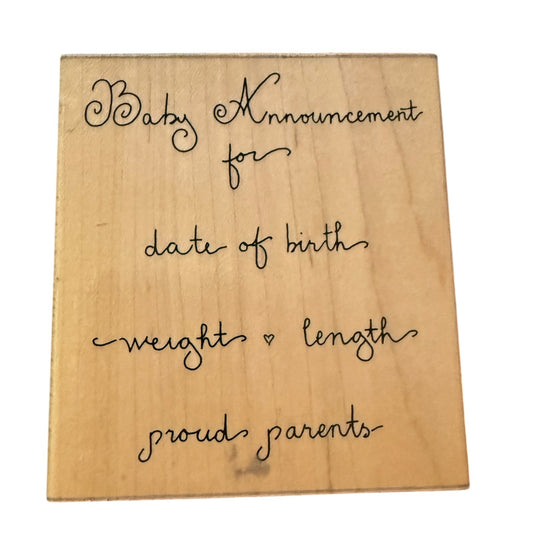 Wooden block with baby announcement text on a white background