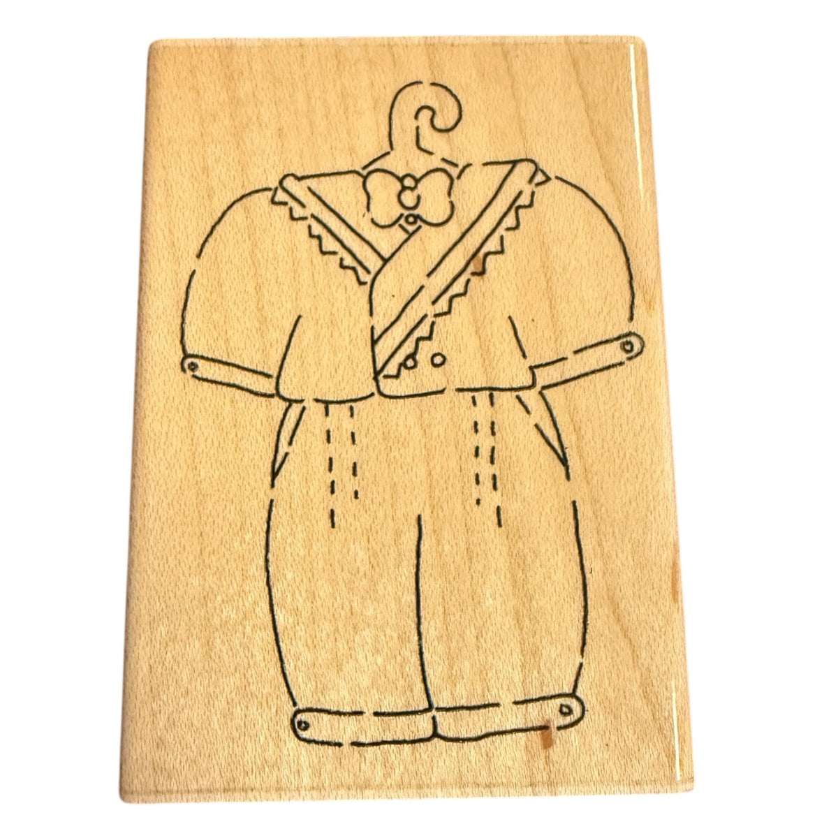 A rectangular wooden stamp featuring a black line drawing of a baby outfit with a bow tie, shown on a plain white background.