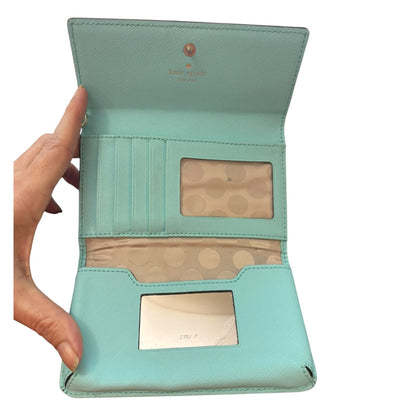 Light blue wallet with brand logo held open by a hand on a white background