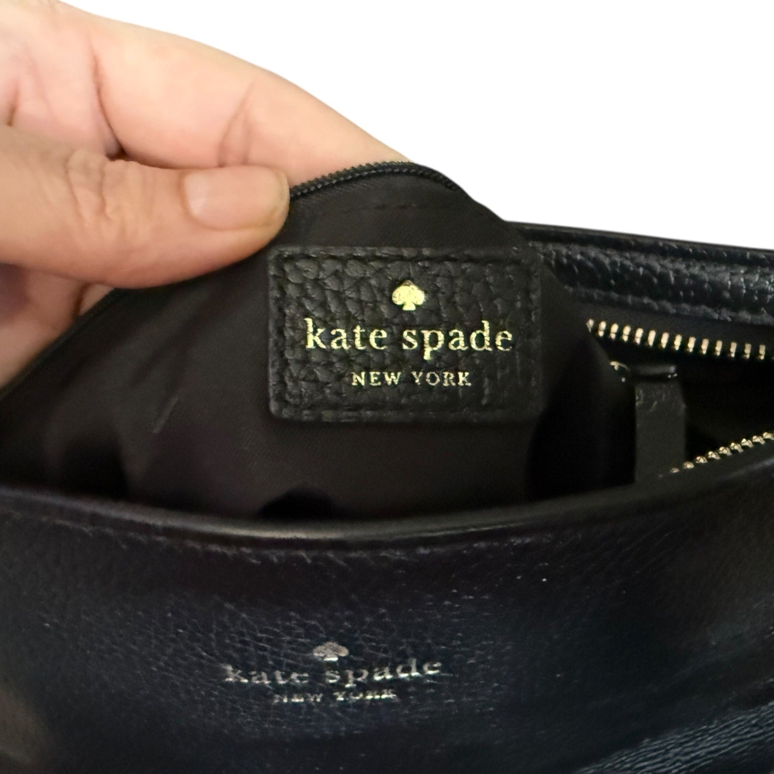 Close-up of a black Kate Spade handbag with a visible brand label.