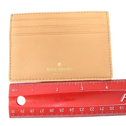 Card holder wallet with Kate Spade logo next to a red ruler for size reference