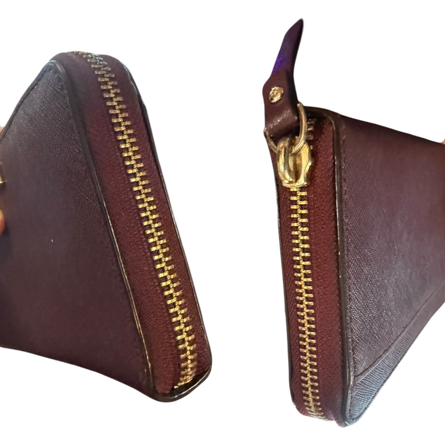 Side view of leather wallet with gold zipper on a white background