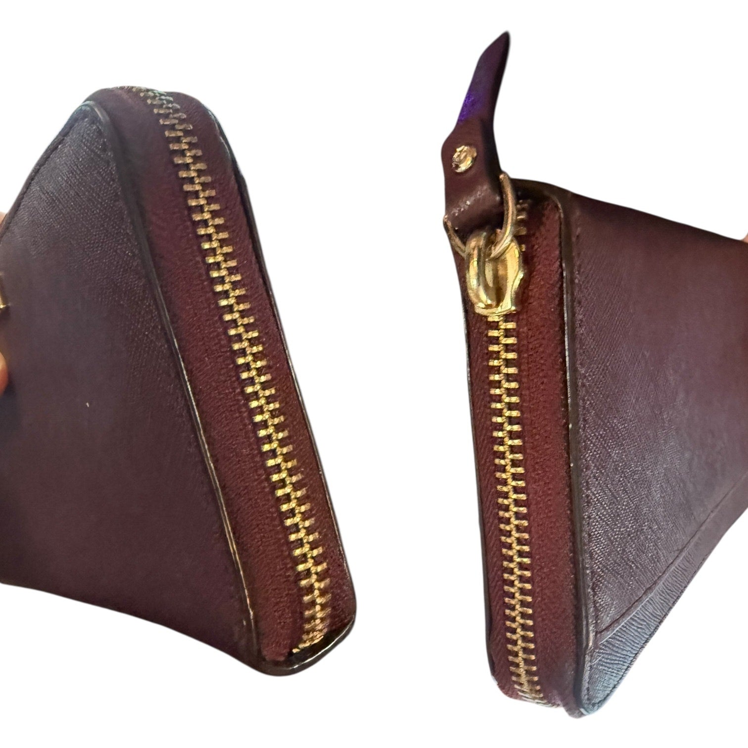 Side view of leather wallet with gold zipper on a white background