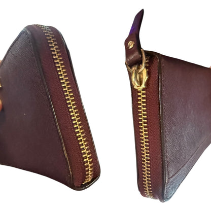 Side view of leather wallet with gold zipper on a white background