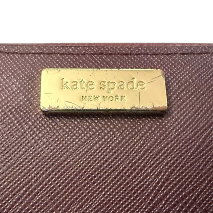 textured wallet with a gold 'kate spade New York' label.