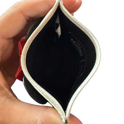 A close-up of a hand holding open a card wallet, showing a black interior with a white stitched edge and a small interior tag.