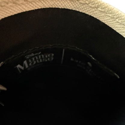 Close-up of the inside of a Disney Minnie Mouse wallet, showing the black inner with white printed Disney Minnie Mouse branding and a light-colored textured fabric edge at the top.