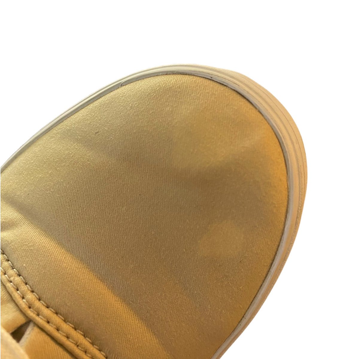 Close-up of a spots on beige canvas shoes on a white background