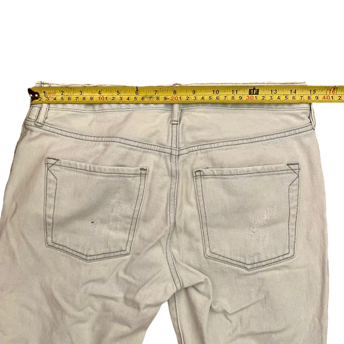 Light blue jeans with a measuring tape on a white background
