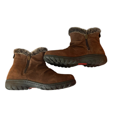 Side of a Pair of brown winter boots with fur trim on a white background