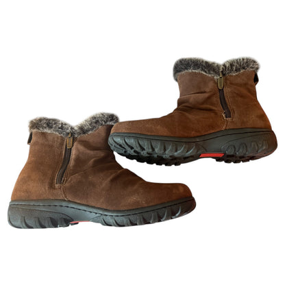 Side of a Pair of brown winter boots with fur trim on a white background