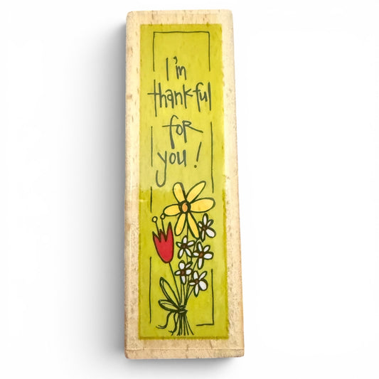 Wooden block stamp with 'I'm thankful for you!' text and floral illustrations on a white background