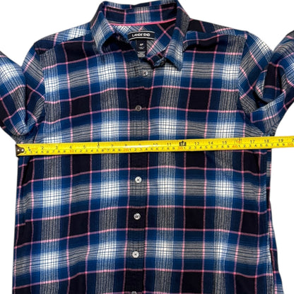 A blue plaid button-down shirt with pink and white stripes, shown with a yellow measuring tape stretched horizontally across the chest to indicate size.