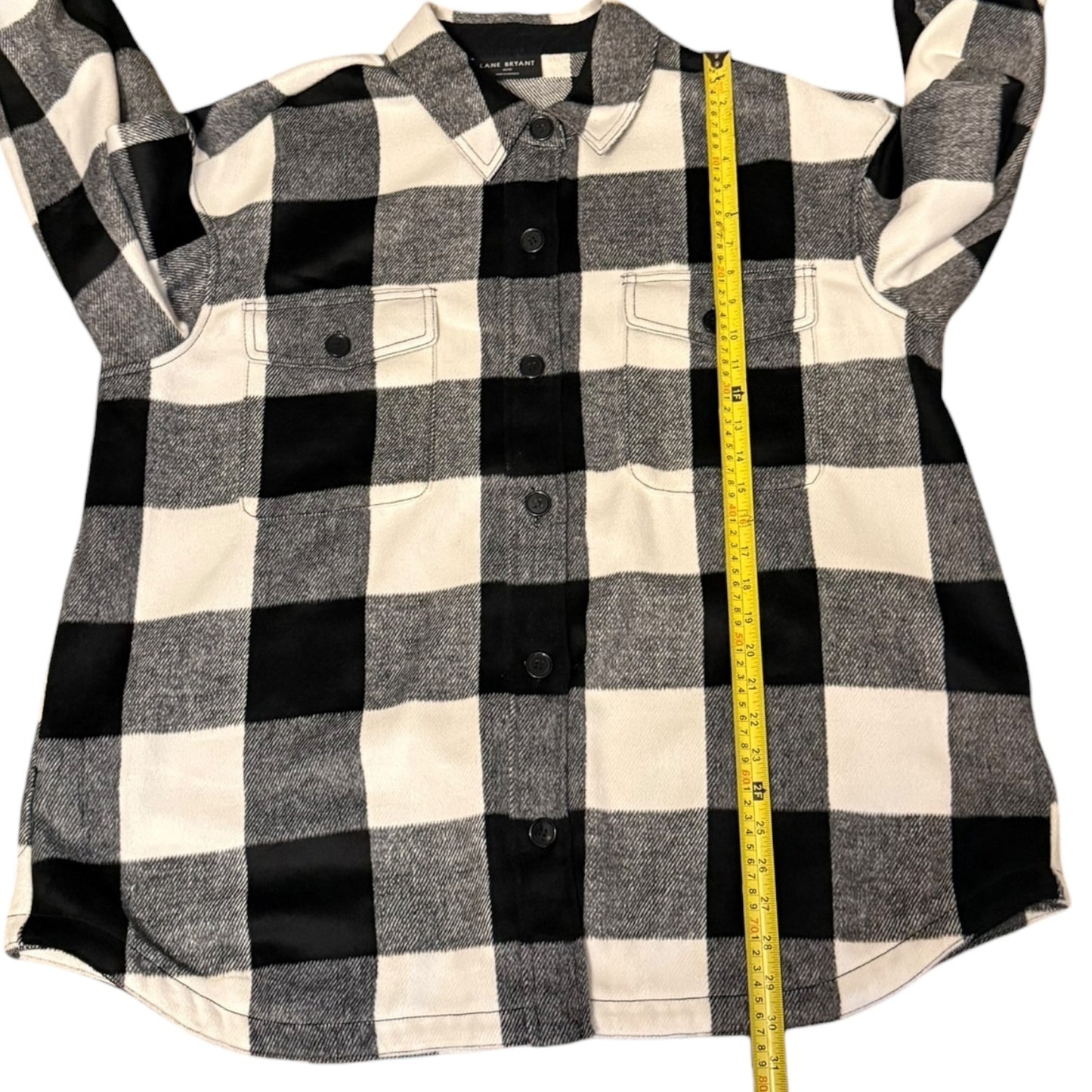 Black and white checkered shirt with a measuring tape on a white background